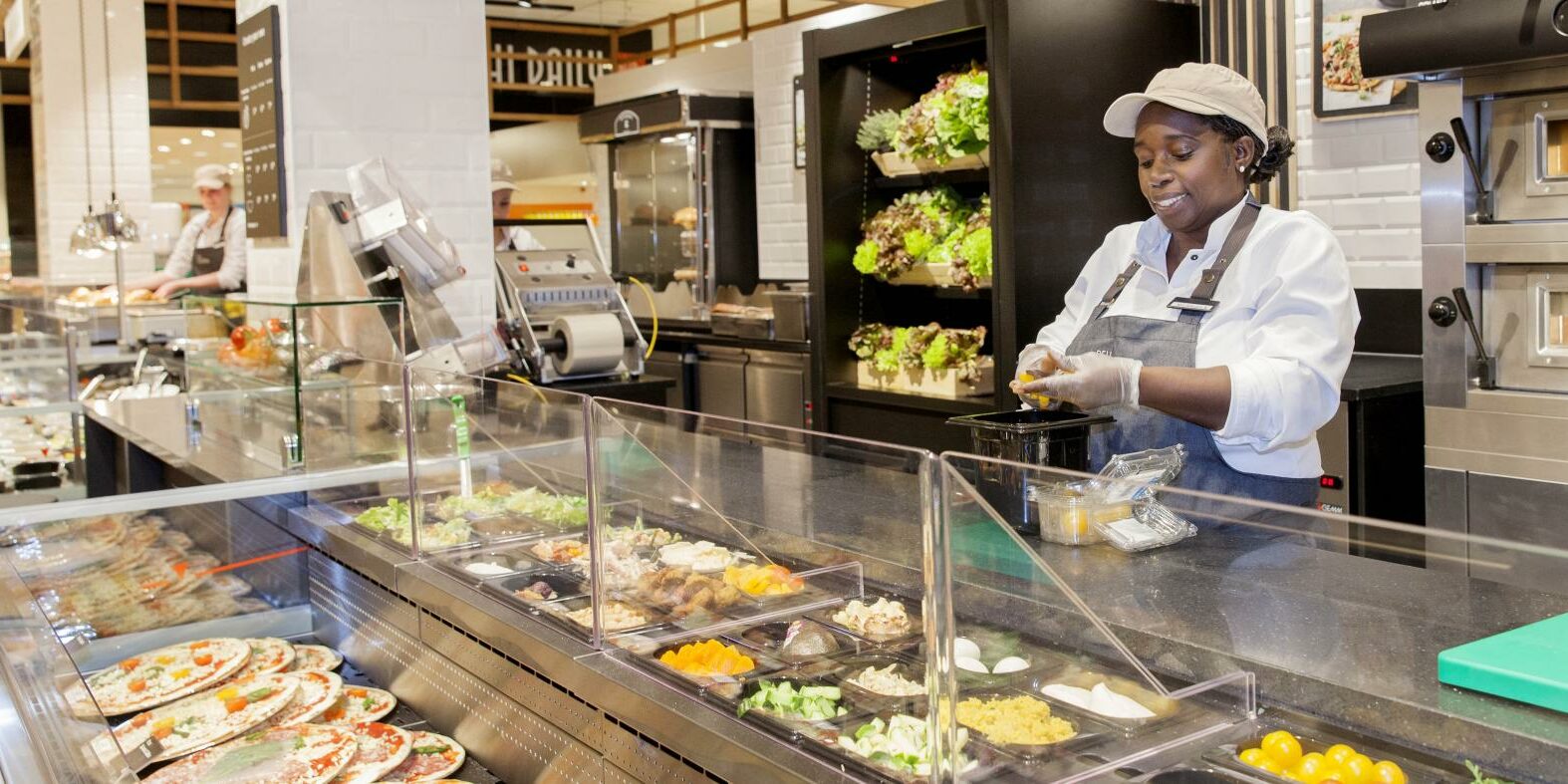 Woman Putting Food in Refrigerated Deli Case From Hess Meat Machines