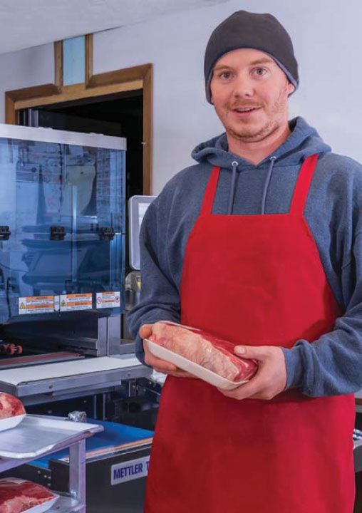 Man From Hess Meat Machines Holding Packaged Meat